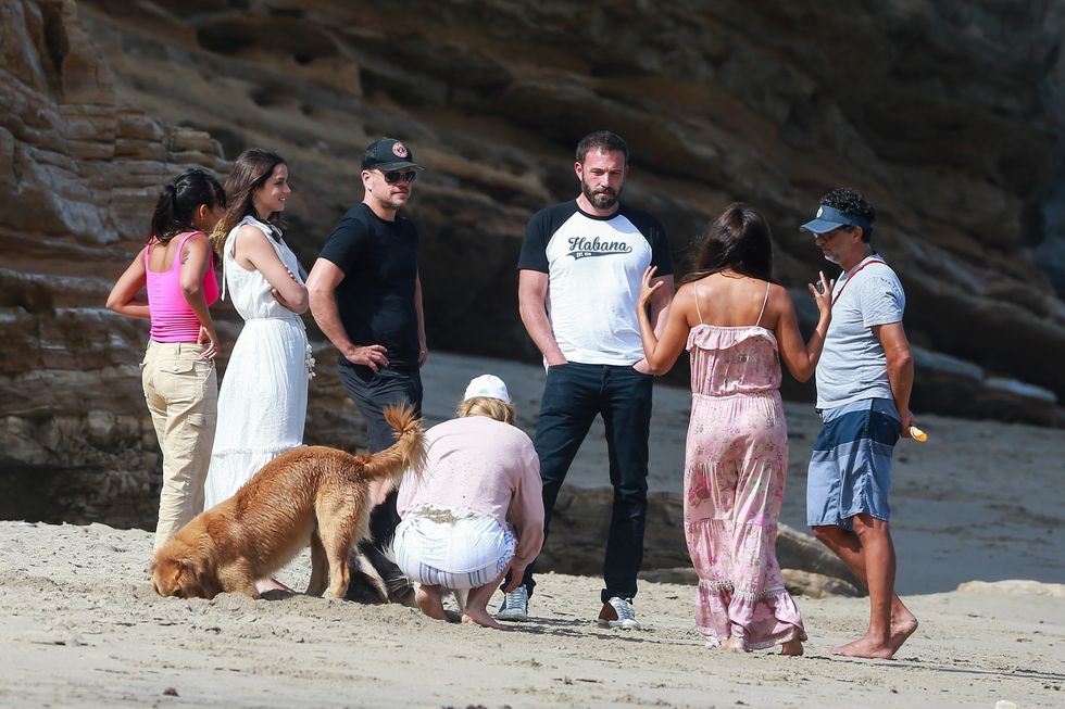 group of ben, ana, matt, luciana and a dog stand on a beach in malibu