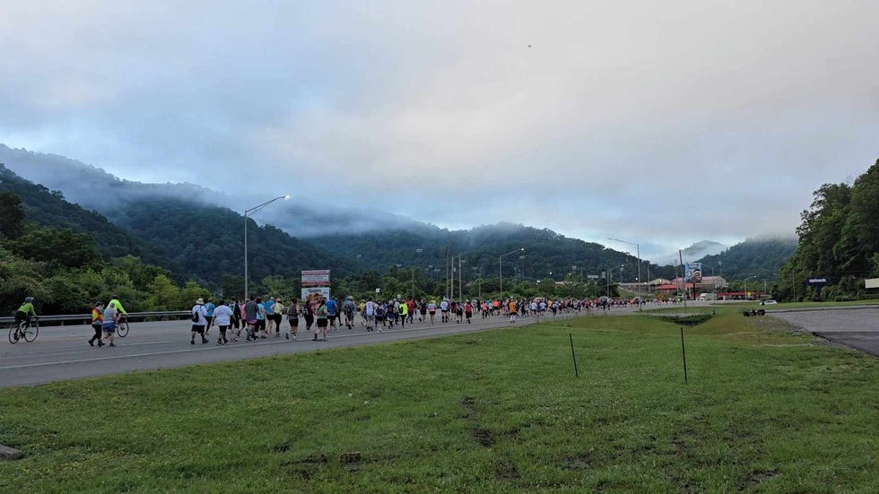 participants walking along a road in a rural mountainous area during an event hatfield mccoy marathon