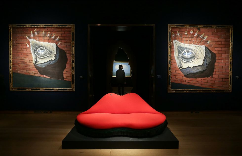 topshot   an artwork by spanish artist salvador dali, entitled "mae west lips sofa", with an estimated price of 400,000 600,000 gbp 470,000 707,000 eur 497,000 746,000 usd, is pictured in front of artworks by dali entitled "l'oeil fleuri, décor pour le ballet tristan fou" each with an estimated price of 350,000 550,000 gbp 413,000 648,000 eur 435,000 684,000 usd during a photocall ahead of the impressionist and modern and art of the surreal sales at christie's in london on february 24, 2017  afp  daniel leal olivas  restricted to editorial use   mandatory mention of the artist upon publication   to illustrate the event as specified in the caption photo credit should read daniel leal olivasafp via getty images
