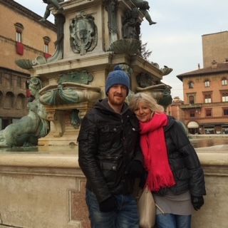 a man and woman posing for a picture in front of a fountain