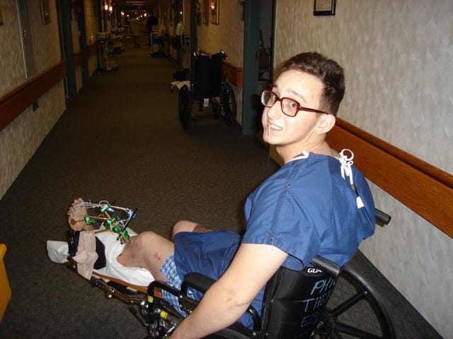 individual in a hospital setting seated in a wheelchair wearing a medical gown