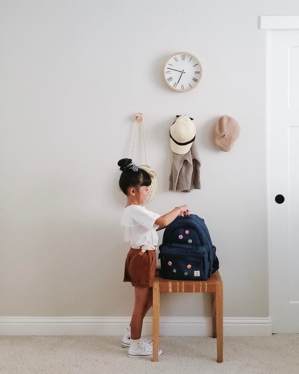girl putting items in backpack