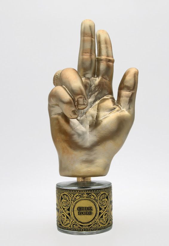 a hand holding a gold and black object