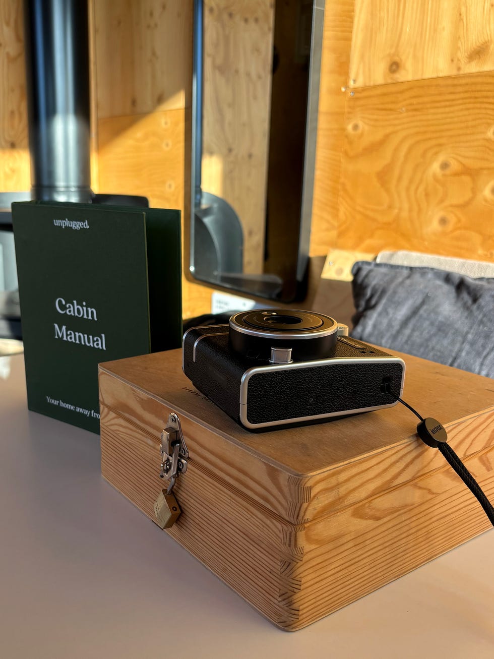 a wooden box on a table with a black polaroid camera on top of it