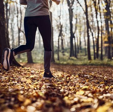 unrecognizable athlete running in autumn day at the park