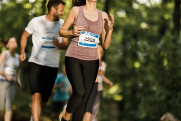 unrecognizable female athlete running a marathon in nature