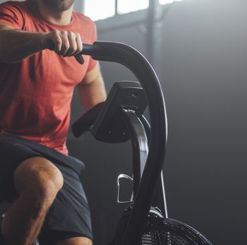 unrecognizable man doing exercise on a gym stationary bike, gym concept