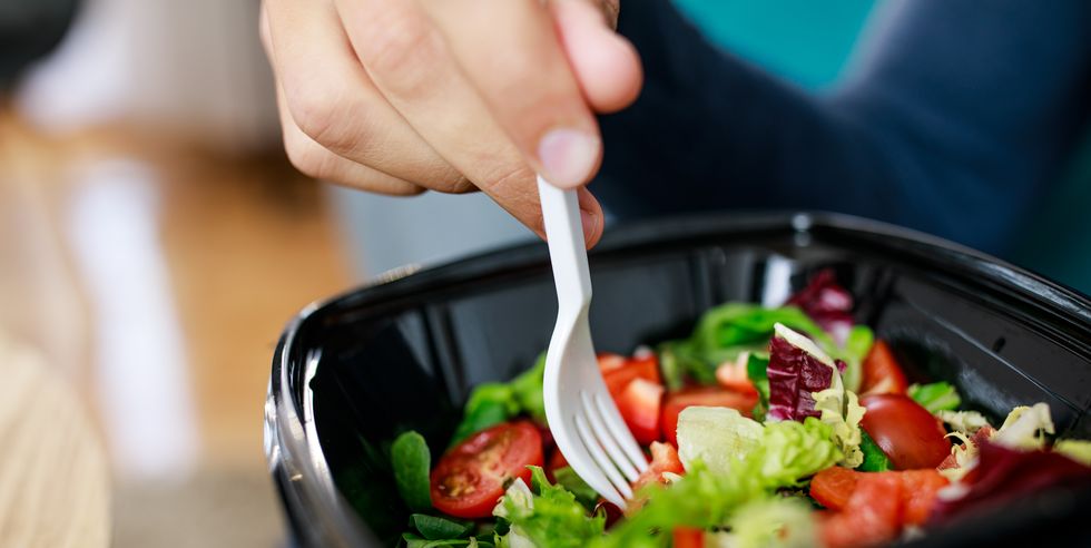 unrecognizable man enjoying a healthy takeaway salad for lunch