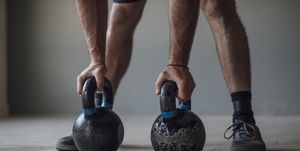 unrecognizable man exercising with kettlebells, cross training concept, a close up