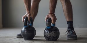 unrecognizable man exercising with kettlebells, cross training concept, a close up