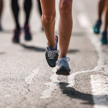 unrecognizable marathon runner in motion on the road.
