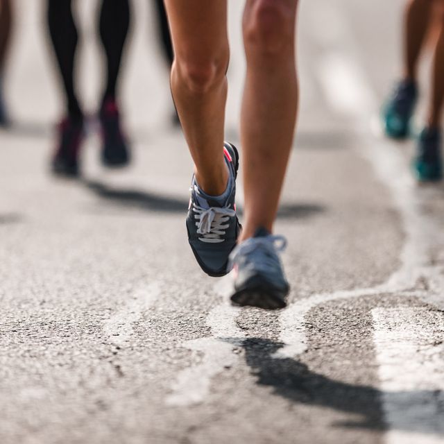unrecognizable marathon runner in motion on the road.