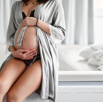 mujer embarazada sentada cama