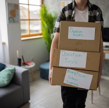 unrecognizable redhead teenage boy,carring the cardboard boxes for donation