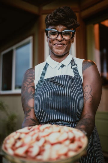 Freshly baked pie held by a person in a striped apron