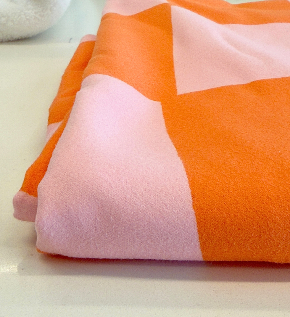 a close up of a pink and orange microfiber towel from dock & bay