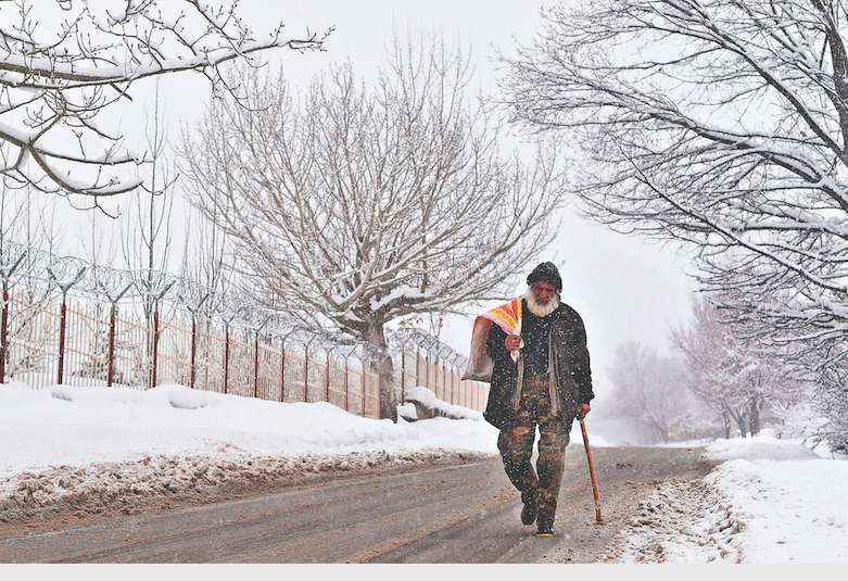 un uomo cammina sotto la neve nel distretto di paghman