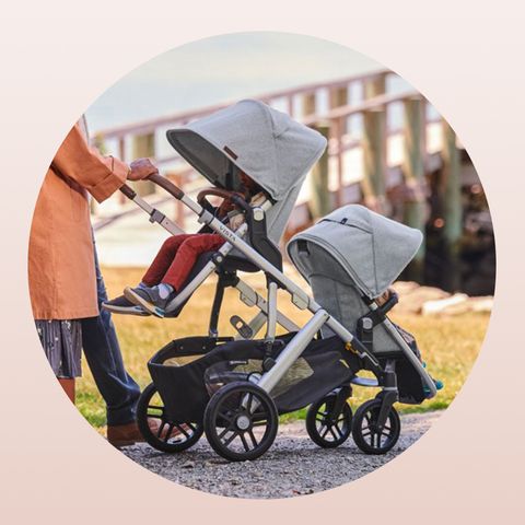parents pushing uppababy single to double stroller