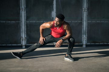 Urban athlete exercising and stretching legs