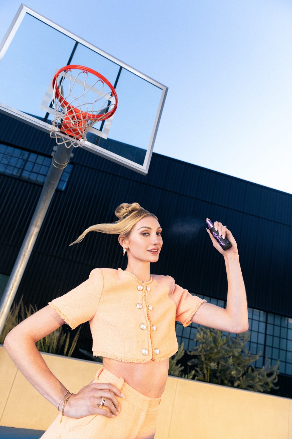 a person spraying a product near a basketball hoop