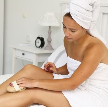 una mujer usando dry brushing para su piel