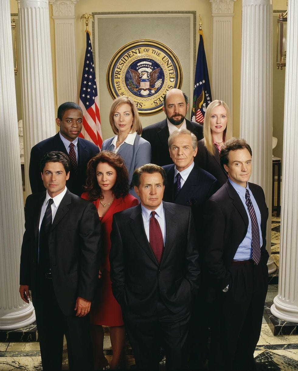 group of individuals posing in front of the presidential seal