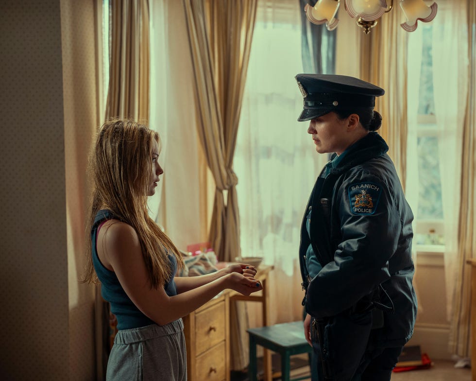 a police officer interacts with a young woman in a domestic setting