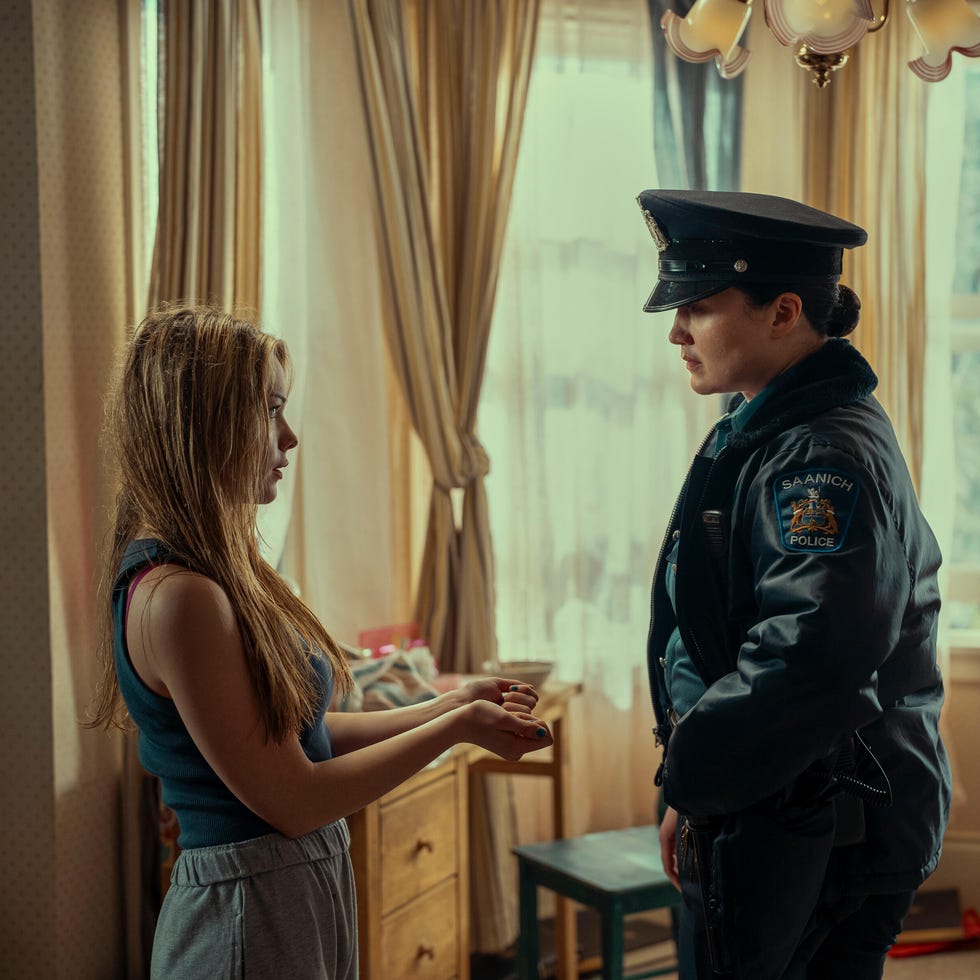a police officer interacts with a young woman in a domestic setting a police officer interacts with a young woman in a domestic setting