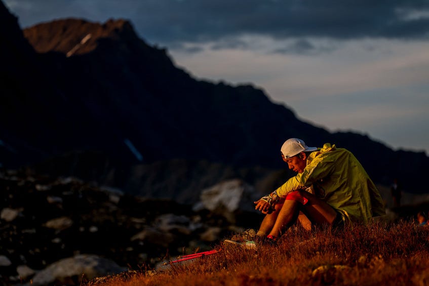 runner sitting on a mountain at night