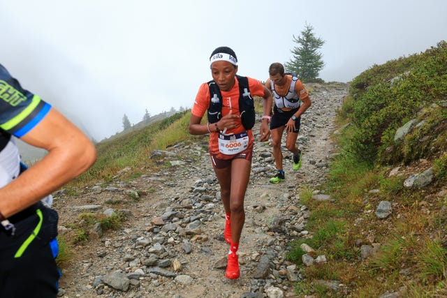 trail runners navigating a rocky path in a mountainous area