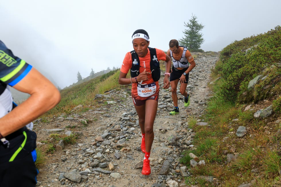 trail runners navigating a rocky path in a mountainous area