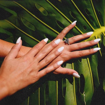 a woman's hand holding a yellow flower