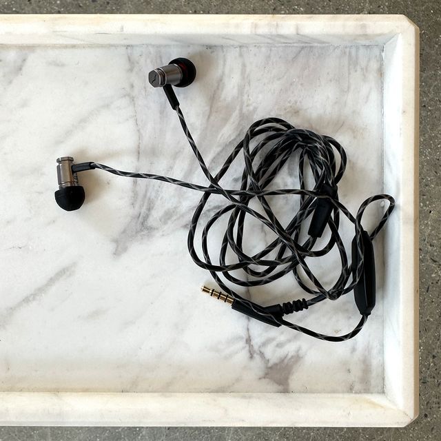 v moda forza metallo wired in ear headphones on marble tray