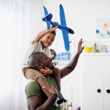 vader en zoon spelen met speelgoedvliegtuig
