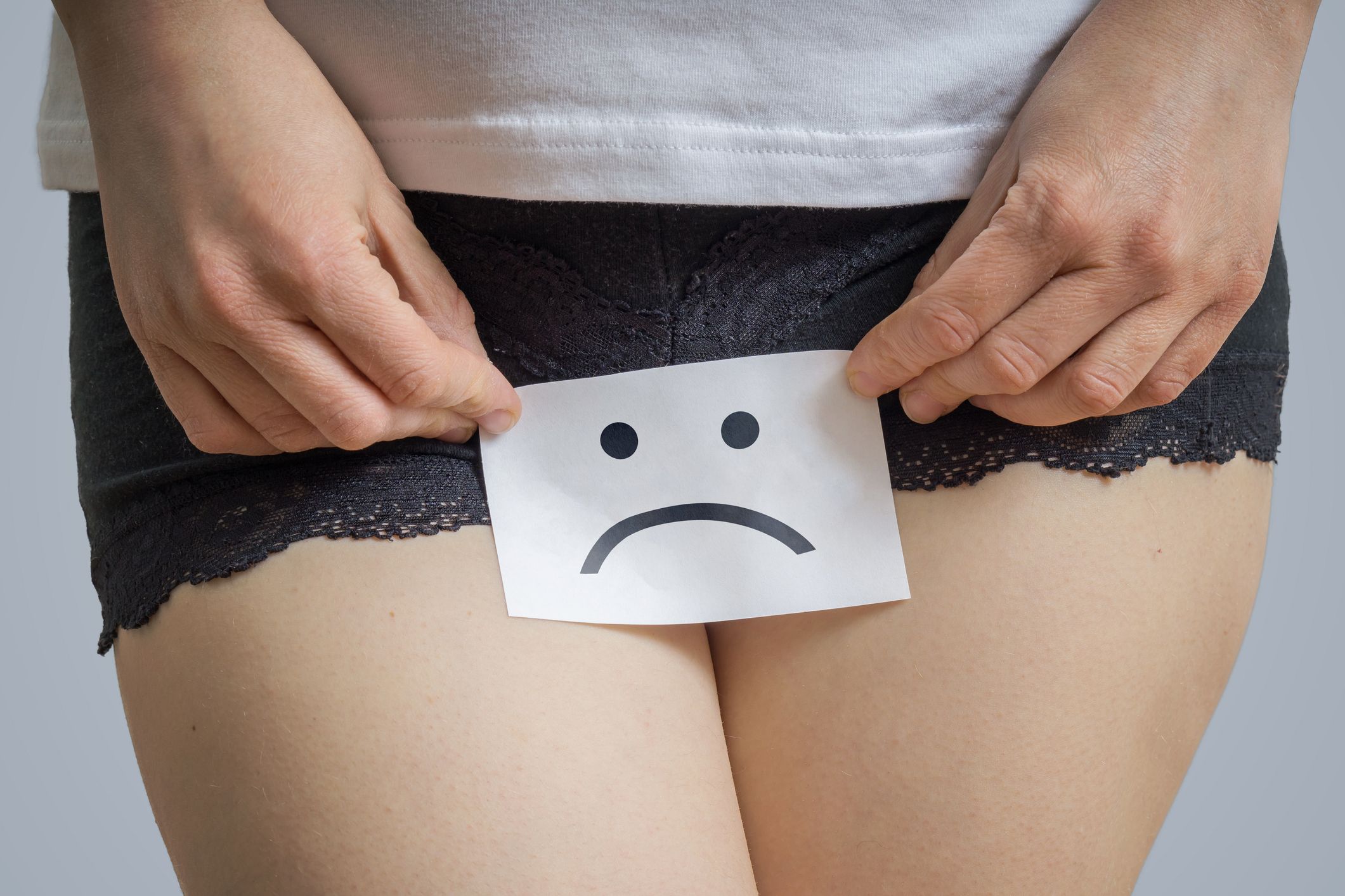 vaginal or menstrual problems concept young woman holds paper with sos above crotch