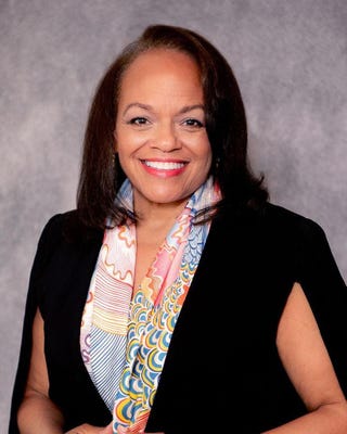 portrait of a woman wearing a colorful scarf and a black top