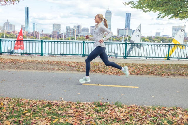 parker valby running next to water with city skyline in background