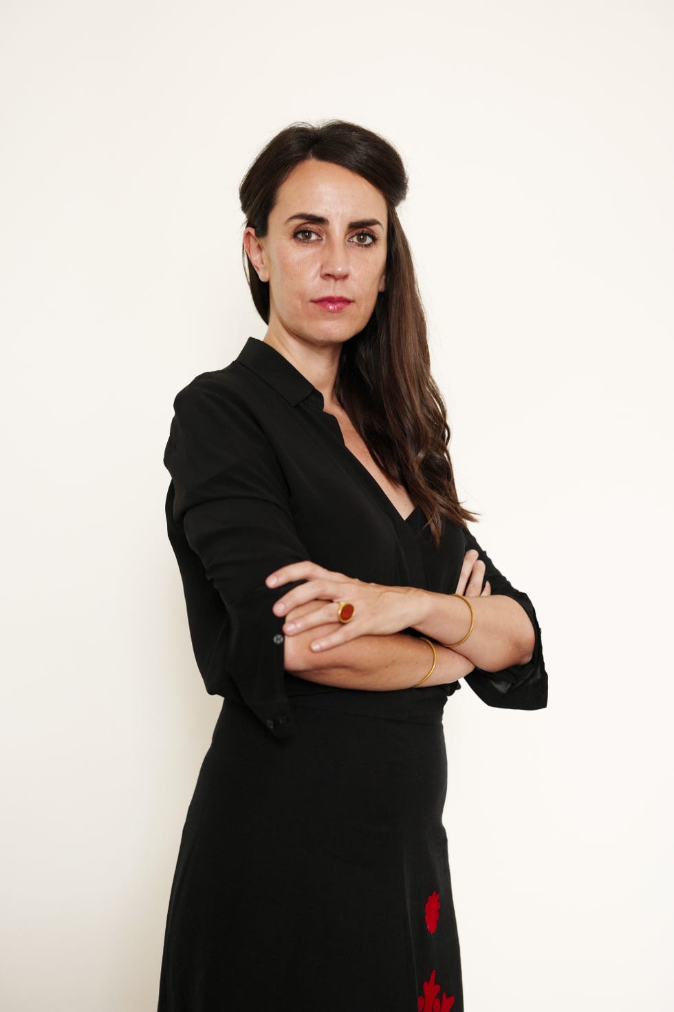 a person with arms crossed wearing a black blouse and skirt