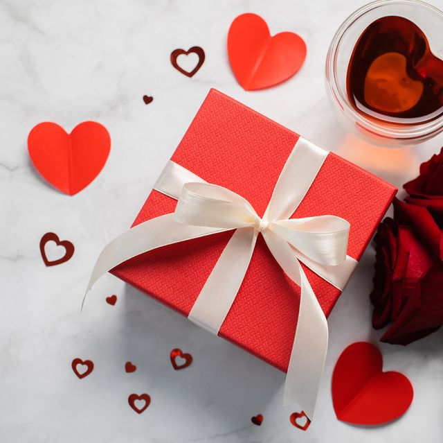 valentine's day background gift box, red roses, hot tea in cup and aper hearts on background flat lay, directly above, copy space