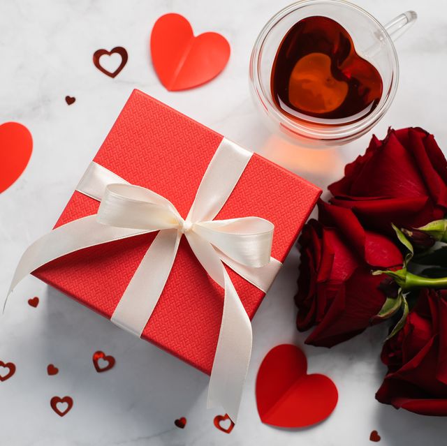 valentine's day background gift box, red roses, hot tea in cup and aper hearts on background flat lay, directly above, copy space