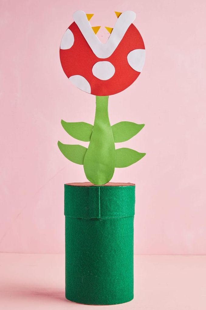 tall, green, cylindrical valentine's day box with carnivorous plant made from paper cutouts appearing to spout from lid