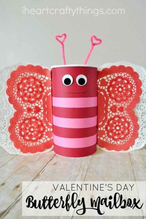 red and pink butterfly valentine box made from recycled oats container, doily wings, googly eyes, and pipe cleaner antennae