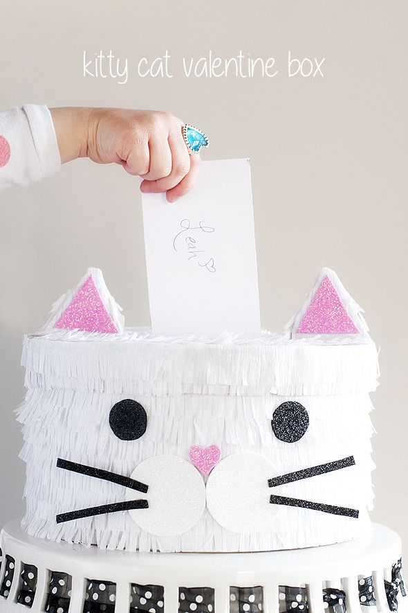 valentine’s day box decorated to look like cat with fringed white crepe paper fur, pink ears and nose, black eyes, whiskers