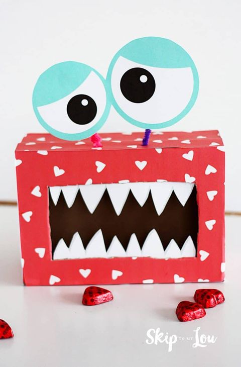 monster valentine box with toothy mouth opening and googly eyes attached by pipe cleaners, covered heart patterned red paper