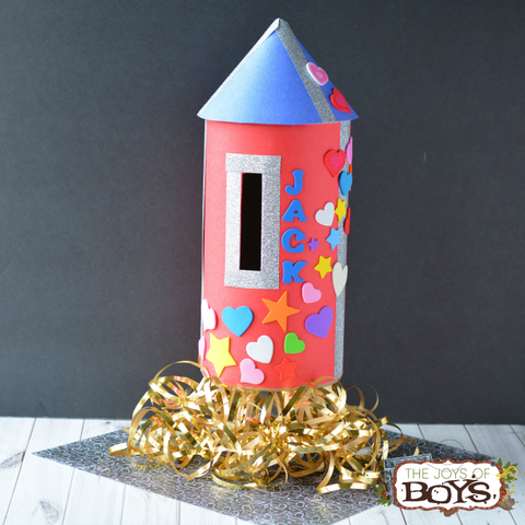 rocket ship valentines day box decorated with stars and hearts and the child's name jack, with curly gold ribbon flame