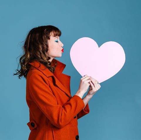 young woman holding paper pink heart