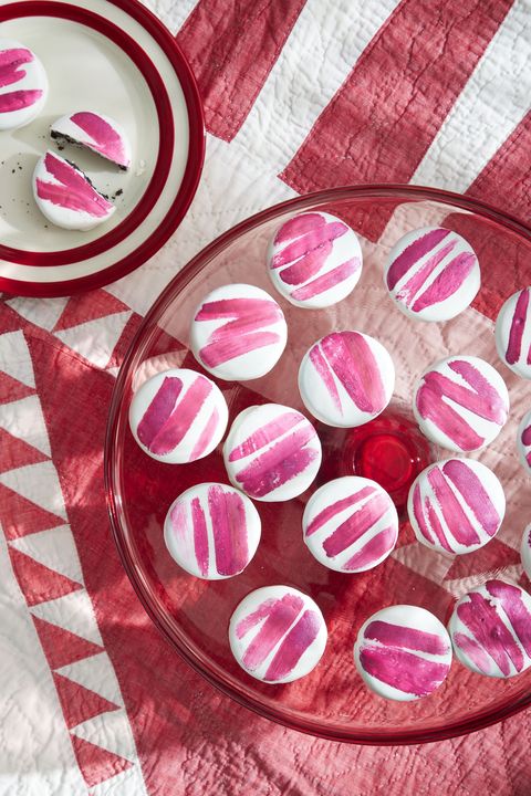 sandwich cookies dipped in chocolate with stripes painted on top with edible paint
