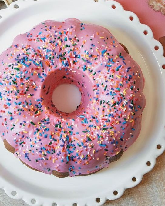 dollys donut coconut bundt cake topped with pink glaze and sprinkles