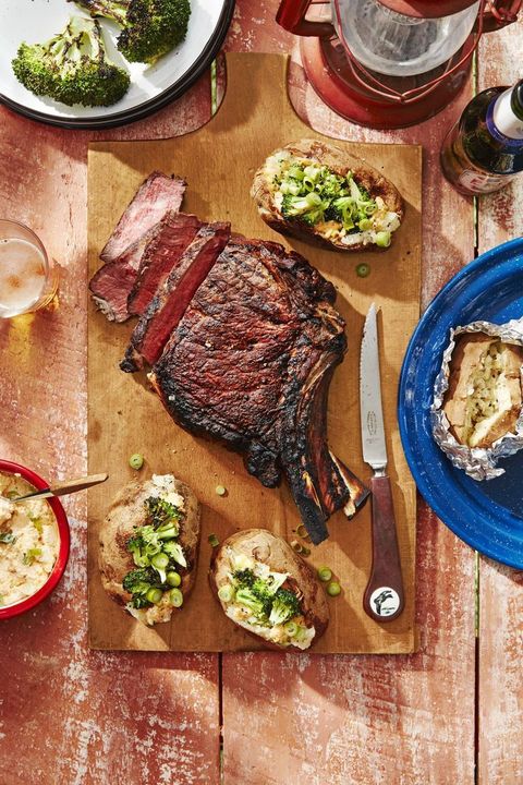 cowboy steaks and potatoes with broccoli and cheddar scallion spread on a wooden serving board