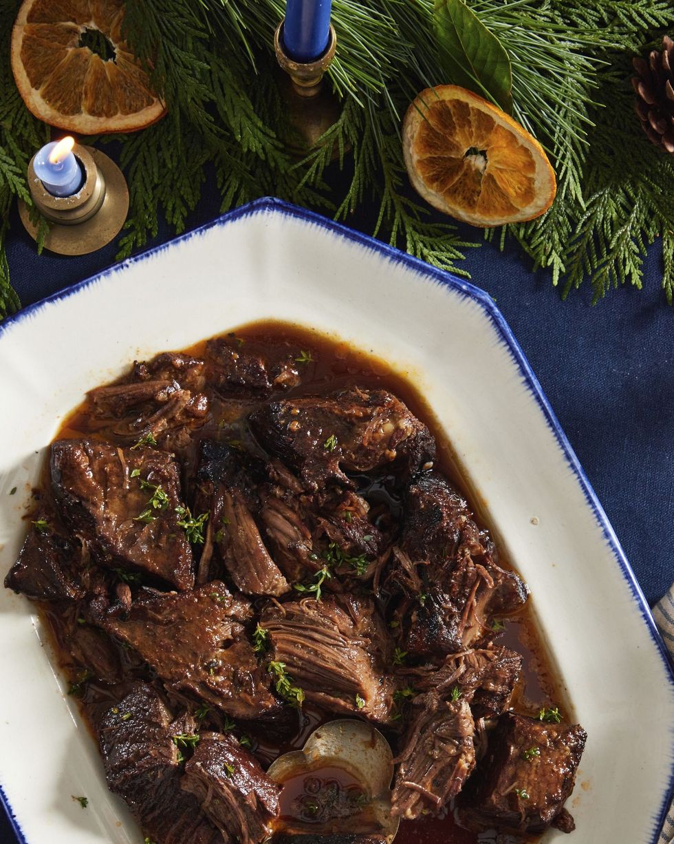 red wine braised short ribs in a white serving dish with a spoon